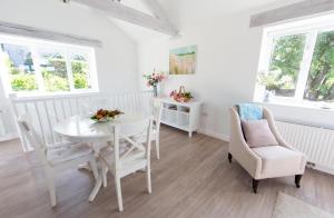 a white dining room with a white table and chairs at 2 Bed in Upper Vobster oc-c39495 in Mells