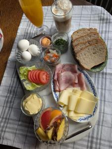 a table with a plate of food with cheese and bread at Lägenhet nära naturen Pralinette BB in Nykroppa