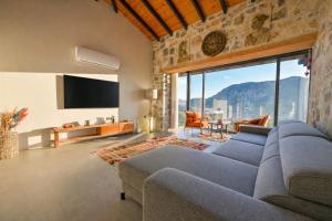 a living room with a blue couch and a tv at Villa Skylight Göcek Fethiye in Fethiye