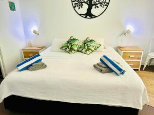 a bedroom with a large bed with towels on it at Sunbird Suite in Palm Cove in Palm Cove