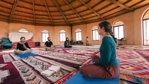 a group of people sitting in a room doing yoga at Zman Midbar Eco Spirit Lodge for Peace in Arad