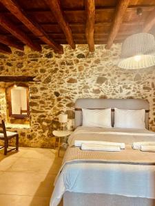 a bedroom with a bed and a stone wall at Harmony Family house in Kerames
