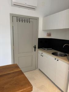 a kitchen with a white door and a sink at Bright Romantic Studio near sea in Kaštela