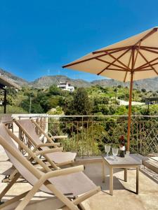 a patio with two chairs and a table with an umbrella at Harmony Family house in Kerames