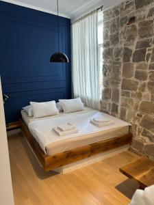 a bedroom with a large bed with a blue wall at Bright Romantic Studio near sea in Kaštela