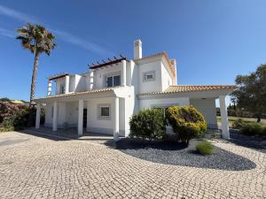 a white house with a palm tree in front of it at Paradise Villa Cabanita Loulé in Loulé