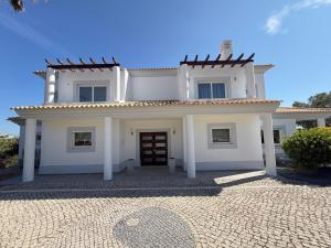 a white house with a red door at Paradise Villa Cabanita Loulé in Loulé