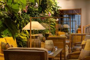 a room with a table with a lamp and plants at Hotel Pas De Calais in Paris