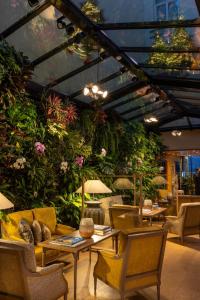 a room with tables and chairs and plants at Hotel Pas De Calais in Paris