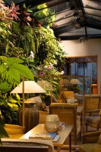 a restaurant with tables and chairs and plants at Hotel Pas De Calais in Paris +104 photos