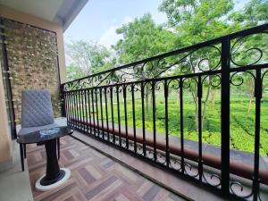 a black fence with a chair on a balcony at Tusker Tea County in Mal bazar