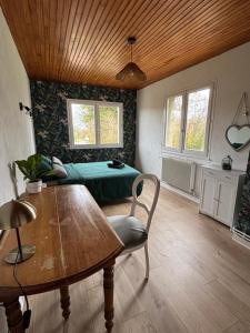 a living room with a table and a bed at Maison chaleureuse de village - location à la chambres in Lanans