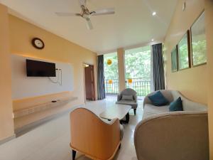 a living room with a couch and a tv at Tusker Tea County in Mal bazar