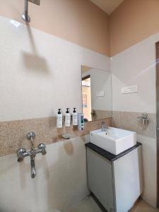 a bathroom with a sink and a mirror at Tusker Tea County in Mal bazar +27 photos