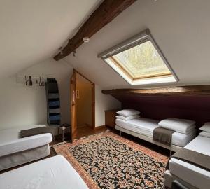 a attic room with two beds and a window at Le Petit Château de Harzé - Spa de nage chauffé toute l'année in Aywaille
