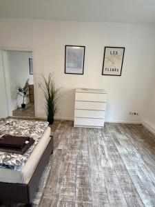 a bedroom with a bed and a dresser in it at Modernes Apartment im Grünen in Kroppach