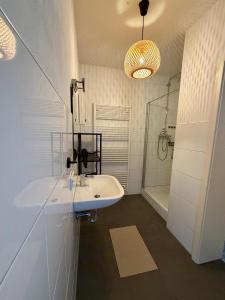 a white bathroom with a sink and a shower at Modernes Apartment im Grünen in Kroppach