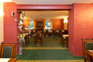 a dining room with tables and chairs and red walls at Waren Müritz Hotel Harmonie in Waren