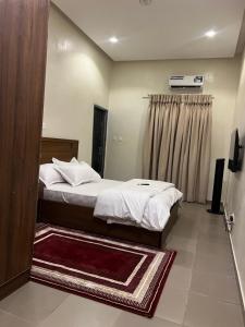 a hotel room with two beds and a window at The Mishkan Apartments in Kaduna +4 photos