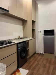 a kitchen with a washing machine and a stove at The Mishkan Apartments in Kaduna