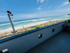 a balcony with a view of a beach and the ocean at Hotel Lean at 83 in Ahangama
