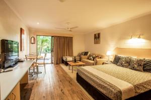 Habitación de hotel con cama y sala de estar. en Pialba Motor Inn, en Hervey Bay