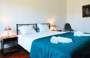 a bedroom with a large bed with towels on it at Quinta dos Choupos in Coimbra