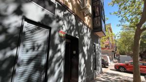 a building with a garage door on the side of a street at Hostal Alcorcón in Alcorcón