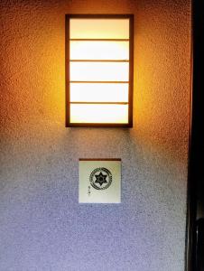 a window on a wall with a picture on it at ゲストハウス青い輝き in Marugame