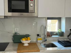 a kitchen with a sink and a bowl of fruit at Casa das Romãs in Torre de Moncorvo +14 photos