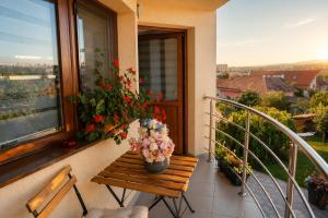 a balcony with a wooden bench and flowers on a window at NATURA Garden in Cluj-Napoca