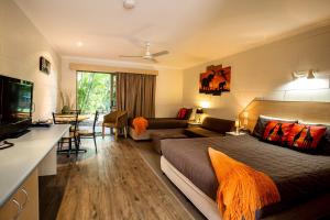 a bedroom with a bed and a living room at Pialba Motor Inn in Hervey Bay