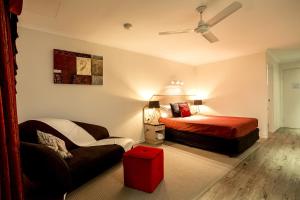 um quarto com uma cama, uma cadeira e um sofá em Pialba Motor Inn em Hervey Bay