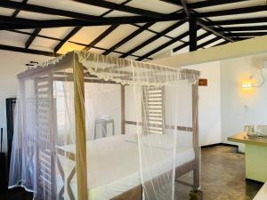 a bedroom with a bed with a mosquito net at Hotel Lean at 83 in Ahangama