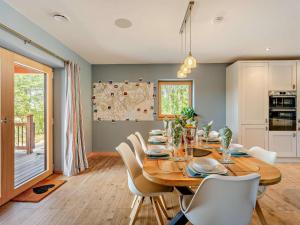 a dining room with a wooden table and white chairs at 4 Bed in Kippford oc-95234 in Kippford