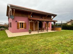 a pink house with a picnic table in a yard at Le ptit Sabot in Corcieux