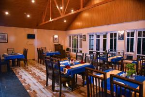 a restaurant with blue tables and chairs in a room at Anutri Hotels & Resorts in Jāmb