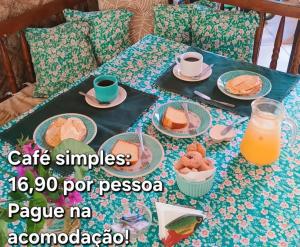 a table topped with plates of food and orange juice at Pousada Renascer in Mangaratiba