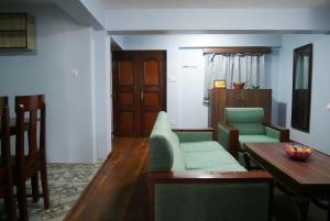 a living room with green chairs and a table at Serenity stay in Kathmandu