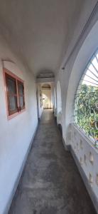 an empty hallway in a building with windows at Saraswati Kunj in mayapur +49 photos