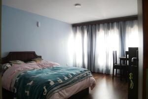 a bedroom with a bed and a window with curtains at Serenity stay in Kathmandu