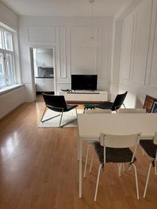 a white living room with a table and chairs at Charmigt boende på i centrala Helsingborg in Helsingborg