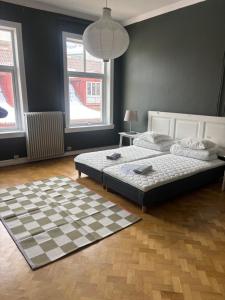 a bedroom with two beds and a checkered floor at Charmigt boende på i centrala Helsingborg in Helsingborg
