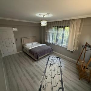 a bedroom with a bed and a wooden floor at Begonvil Konaklama in Sapanca +8 photos