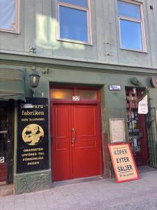 a red door of a store with a sign in front at Charmigt boende på i centrala Helsingborg in Helsingborg