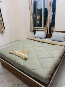 a large bed in a room with a window at manoj lodge in Sangamner