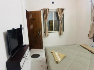 a room with a bed and a tv and a window at manoj lodge in Sangamner +13 photos
