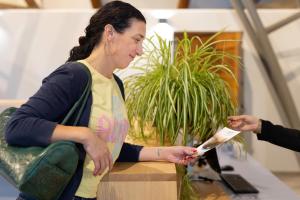 a woman sitting at a table looking at a paper at Brit Hotel Du Ban in Chaudes-Aigues +27 photos