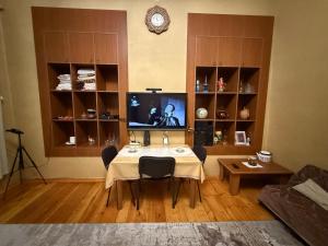 a living room with a table with chairs and a television at Vintage Stile in Ganja