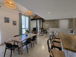 a dining room with wooden tables and chairs at La Remise loft de caractère et grand garage in Collobrières
